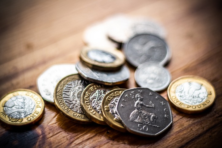 New Great British Pound GBP Coins laying casually on wooden surface ...