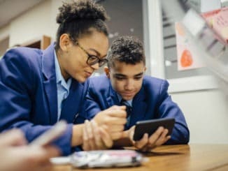 Sneaky Students Using Smartphone In Lesson