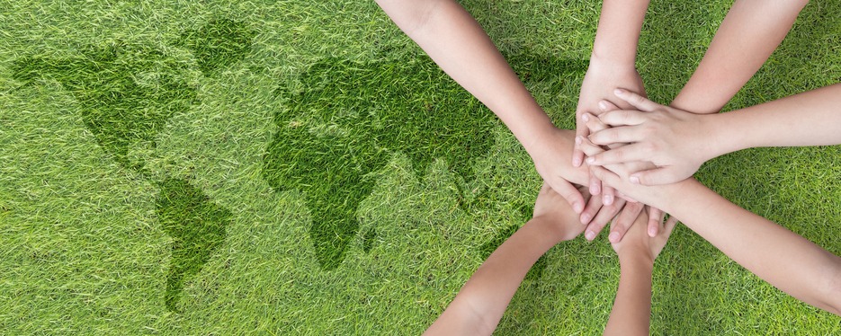 Global community teamwork, CSR and ESG environmental energy saving collaboration among young children with partnership hands stack together on green background for sustainable development goal concept