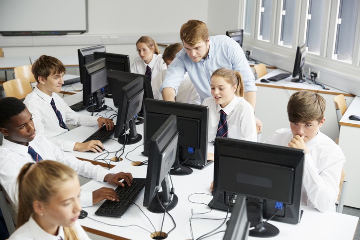 Teenage Students Wearing Uniform Studying In IT Class