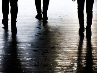 Blurry shadow silhouette of a people walking in the night, detail of legs
