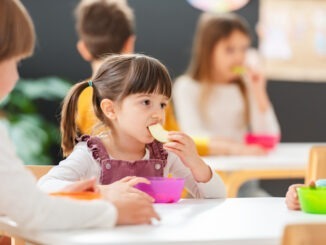 Children eating a fruit snack in a kindergarten