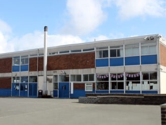 Exterior of English school arts block building with cloudscape background