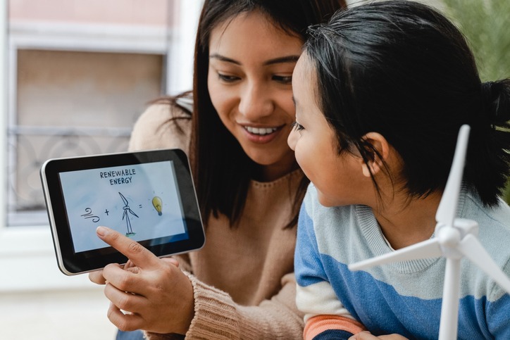Un enfant asiatique apprend les énergies renouvelables alternatives dans une classe d'école maternelle - Focus sur la tablette de maintien de l'enseignant
