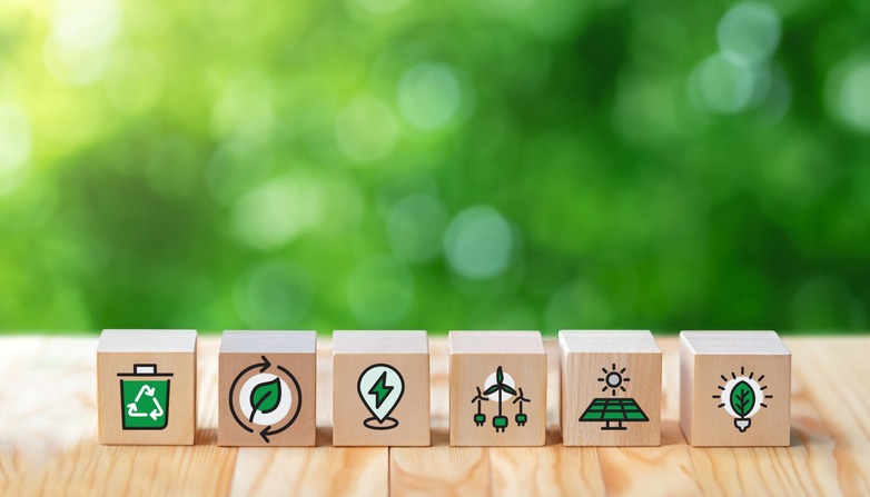 sustainable resources symbols on wooden cube for renewal energy systems with leaves background