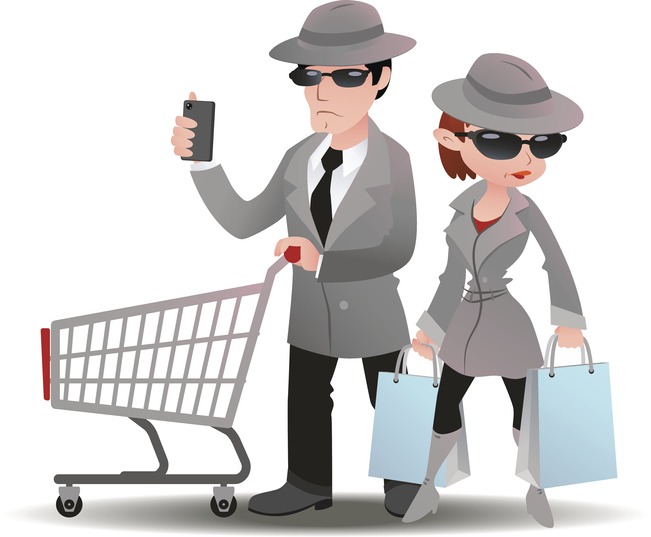 Mystery shopper man with shopping cart and mobile phone and woman with bags in sunglasses, spy coats and hats