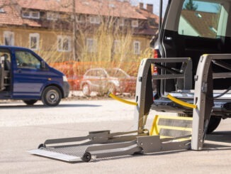 Accessible car with wheelchair lift ramp for person with disability.