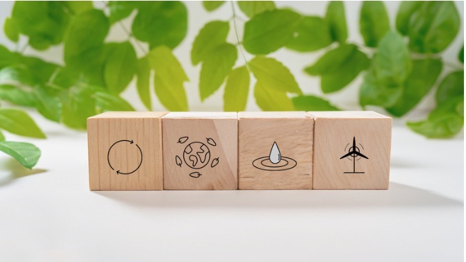 sustainable-resources-symbols-on-wooden-cube-for-renewal-energy-systems-with-leaves-background
