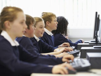 Line Of Children In School Computer Class Doing ICT Work