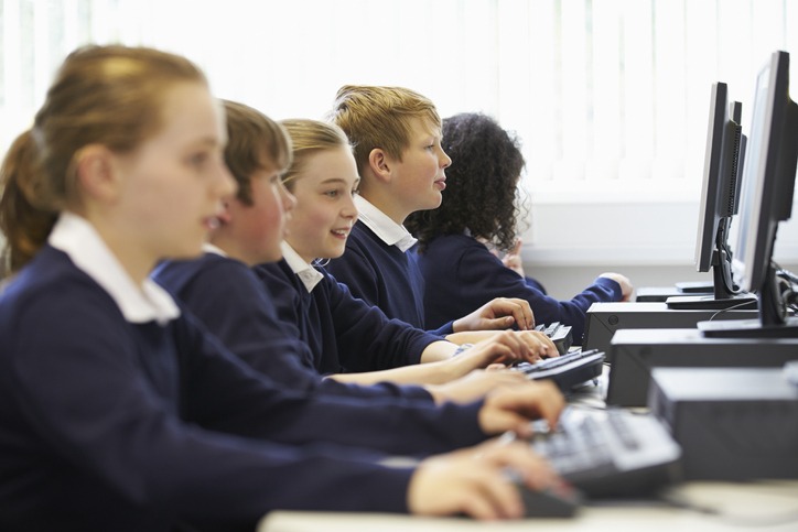 Line Of Children In School Computer Class Doing ICT Work