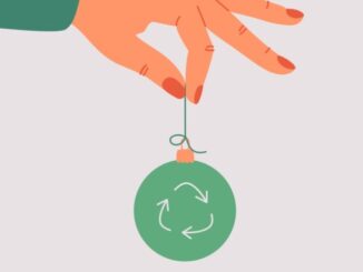 the-human-hand-holds-a-green-xmas-toy-with-a-recycling-symbol
