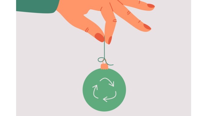 the-human-hand-holds-a-green-xmas-toy-with-a-recycling-symbol
