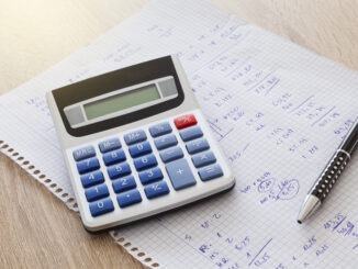 Calculator, paper with numbers and pen