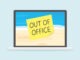 out of office written on sticky note on laptop screen with sandy beach screen saver