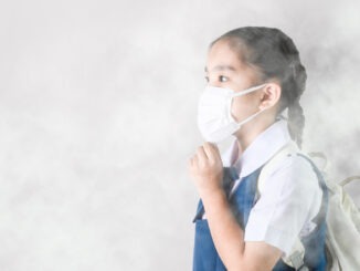 Portrait Asian children girl wear mask to protect PM 2.5 dust and air pollution. Portrait of Thai student wearing protection mask bad weather, pm2.5 concept background