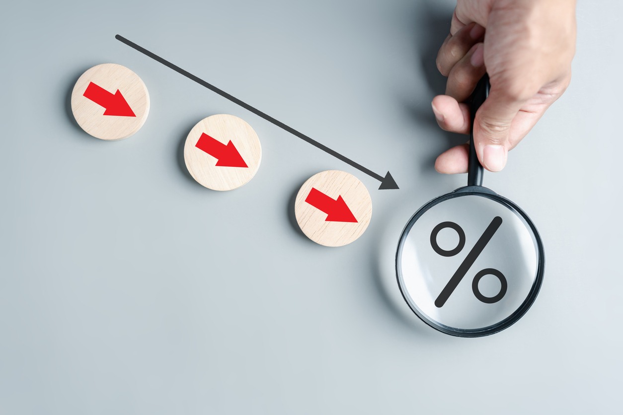 Magnifier focus to Percentage decreasing arrows cost down concept. Financial interest rates decline and profit down of investing.