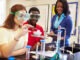 Pupils Carrying Out Experiment In Science Class Wearing Protective Glasses