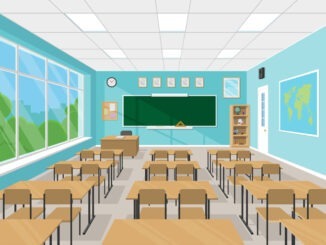 Empty school classroom interior during summer holidays with chalkboard, teacher's table, desks and chairs.