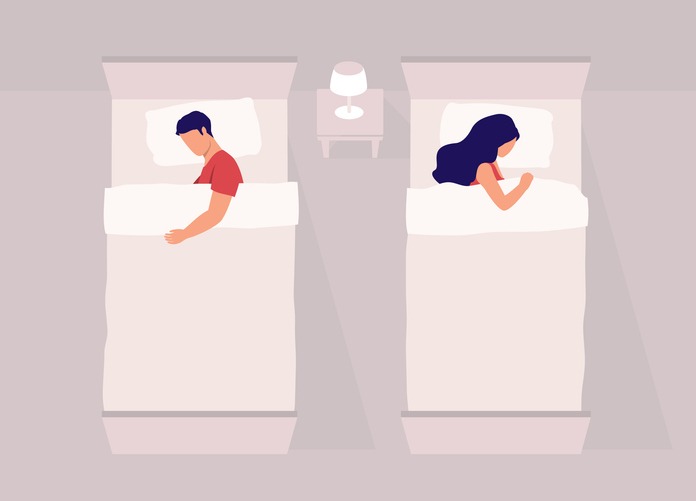 Couple Sleeping Separately In Twin Beds.