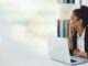 Banner, laptop and woman in office thinking with mockup, bokeh and ideas on business for trading.