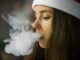 Vape teenager. Young girl in a hat smoking an electronic cigarette