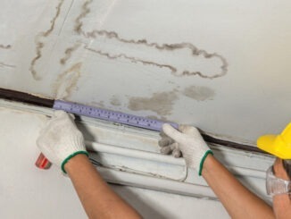 Worker fix leaking pipe in ceiling ,close-up of a stain on the ceiling.