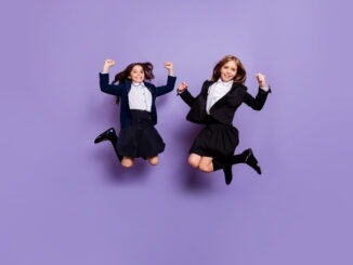 cute cheerful kids raise fists isolated over purple violet background