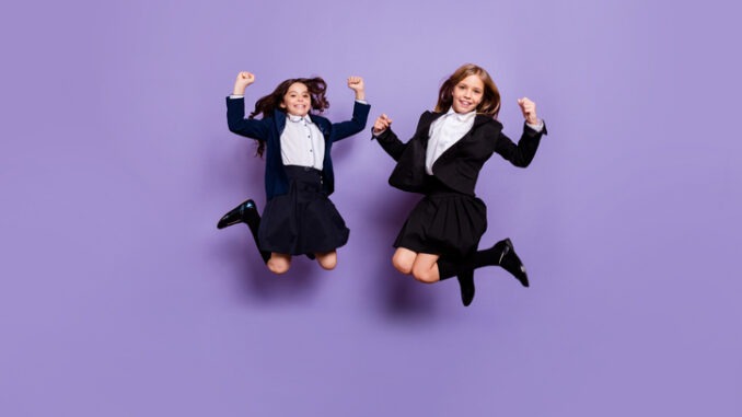 cute cheerful kids raise fists isolated over purple violet background