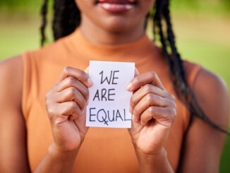 Shot of a unrecognizable woman holding a sign in protest outside