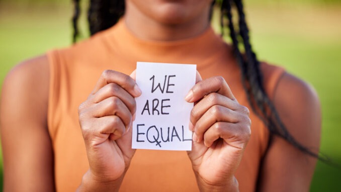 Shot of a unrecognizable woman holding a sign in protest outside