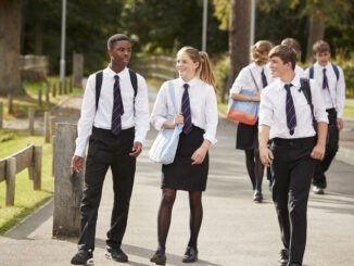 Group Of Teenage Students In Uniform Outside School Buildings