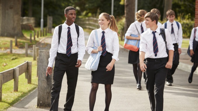 Group Of Teenage Students In Uniform Outside School Buildings 