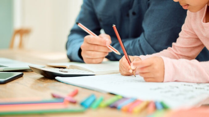 Cropped shot of an unrecognizable little girl being home schooled with some help from her dad