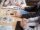 Closeup shot of a group of unrecognisable businesspeople going through paperwork during a meeting in an office