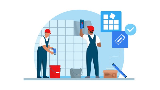 Professional tilers installing tiles on a wall using professional tools,