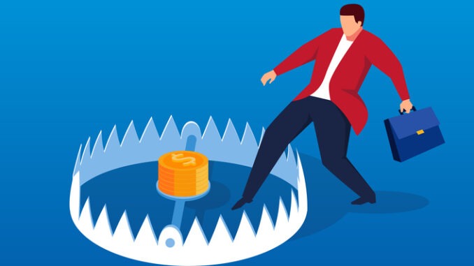 Businessman carefully enters mouse trap