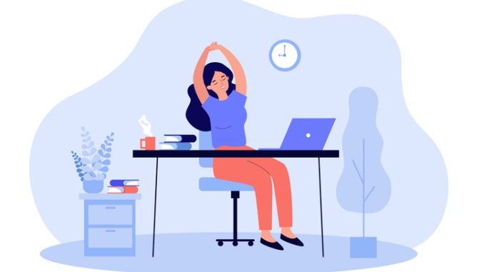 Happy young woman relaxing at workplace in office. Female employee sitting at desk with laptop and stretching during coffee break.