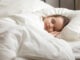 Calm adorable little daughter take day nap. Tranquil preschool child girl covered with white fresh duvet lying in bed comfortable mattress on bedroom. Healthy enough sleeping, zzz, good night, concept