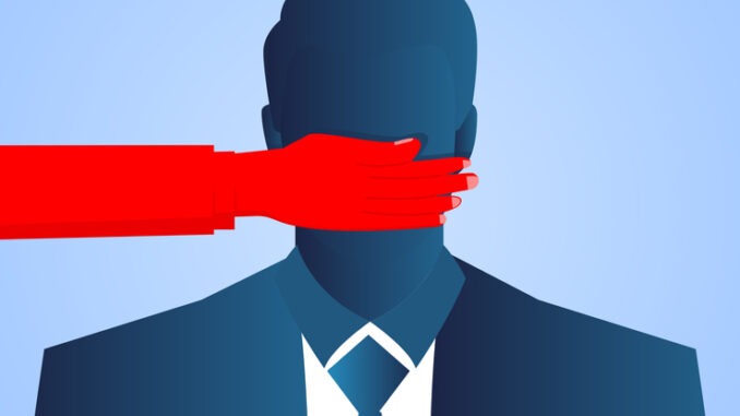Businessman's mouth is blocked by red hands