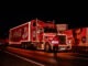 Coca Cola Christmas Truck Tour showcases a vibrant red truck adorned with lights on a city street, enhancing the holiday spirit