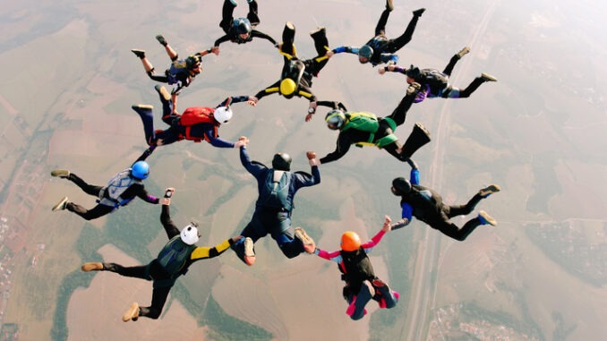 Skydivers holding hands making a fomation. High angle view.