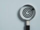 Target board inside of magnifier glass for focus business objective on blue background and copy space.