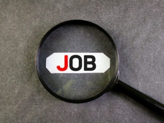 JOB text, word, inscription through a magnifying glass on a black background. Job the concept of finding a job, employment.
