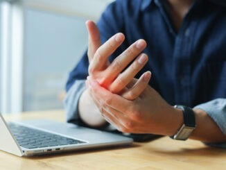 close up young asian man massage on hand palm after hard working to relief pain of stiffness or cramp or carpal tunnel for office syndrome concept