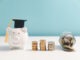 Concept of saving money for education, student loan, scholarship in future. Piggy bank with graduation hat, stack of coins. Earth globe with graduation hat, dollar banknotes on table. Tuition fees