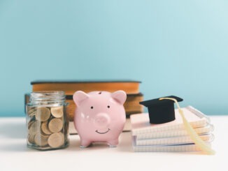 Concept of saving money for education, student loan, scholarship in future. Piggy bank with graduation hat, stack of coins. Earth globe with graduation hat, dollar banknotes on table. Tuition fees