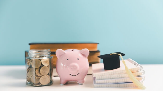 Concept of saving money for education, student loan, scholarship in future. Piggy bank with graduation hat, stack of coins. Earth globe with graduation hat, dollar banknotes on table. Tuition fees