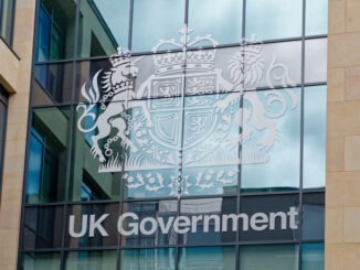 Modern UK government building in Edinburgh. Large text sign and coat of arms on glass windows with reflection on a cloudy day. Edinburgh, UK, 05.03.2025