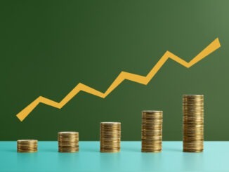 Five stacks of coins with a graph line above - stock photo. Coins arranged as a bar chart with a graph line above