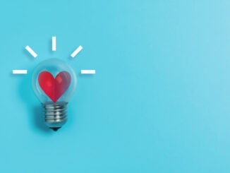 Red heart in light bulb on blue background with copy space. Valentine's day, Creative idea, Inspiration Concept.